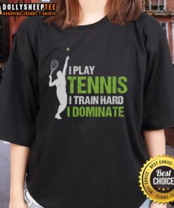 Happy woman playing tennis in a 'I Train Hard, I Dominate' tee, showcasing dedication and skill on the court.