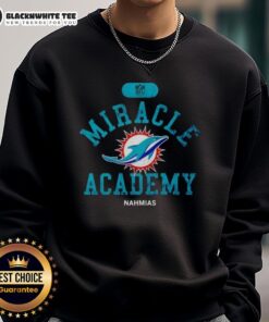 Happy fan in Miami Dolphins sweatshirt at Miracle Academy, showcasing team spirit and NFL pride.