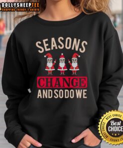 Cozy Christmas sweatshirt featuring 'Happy Seasons Change And So Do We' design, perfect for festive winter celebrations.
