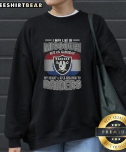 Alt Text: Cozy 'Hot I May Live In Missouri But On Gameday My Heart And Soul Belongs To Raiders' sweatshirt showcasing team spirit.