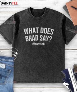 Alt Text: Hot What Does Brad Say Fanovich washed t-shirt displayed on a wooden background, showcasing its soft fabric and design.