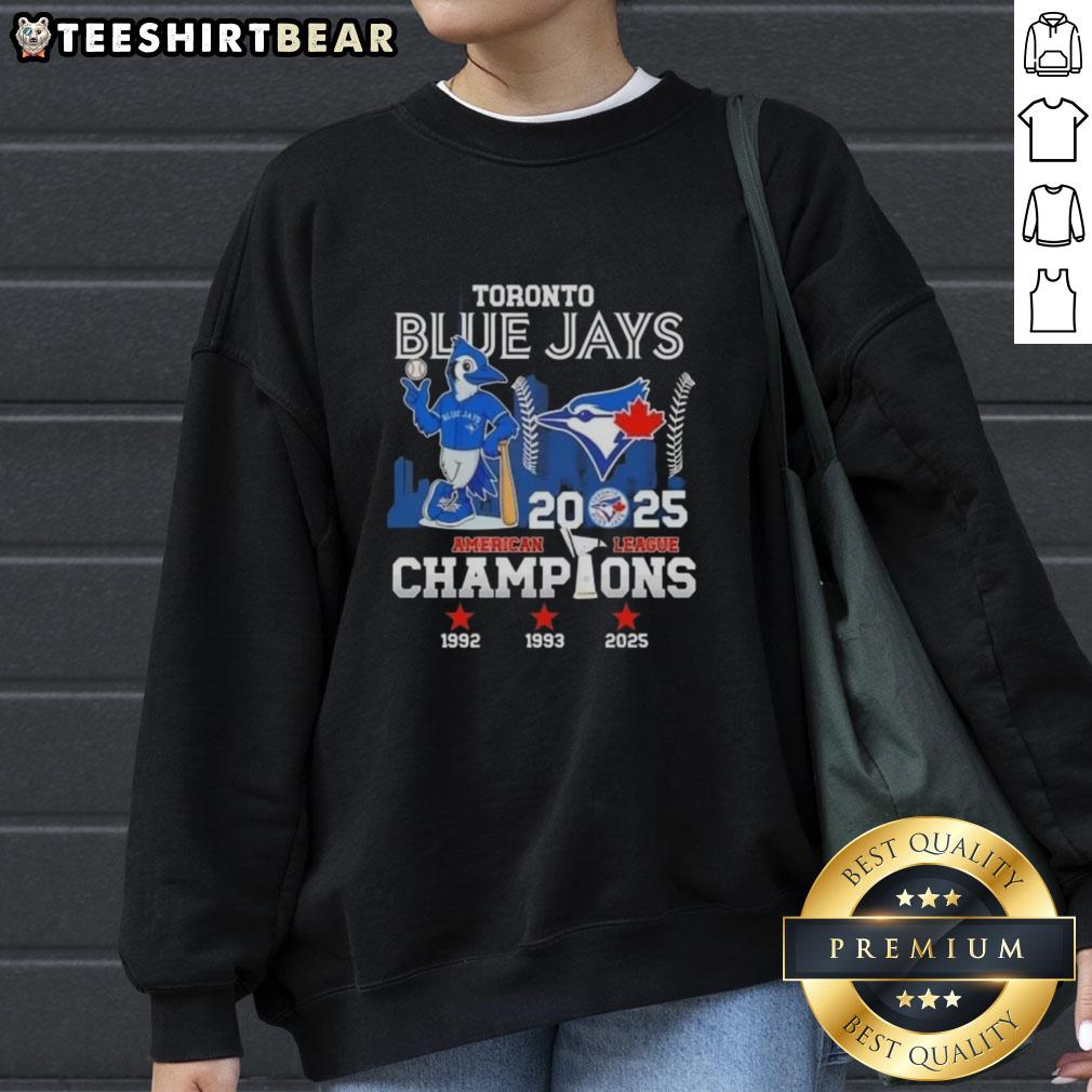 Nice 2025 American League Champions 3x Toronto Blue Jays Mascot Baseball Skyline Sweatshirt Alt Text: Toronto Blue Jays mascot sweatshirt featuring 2025 American League Champions logo and city skyline design.