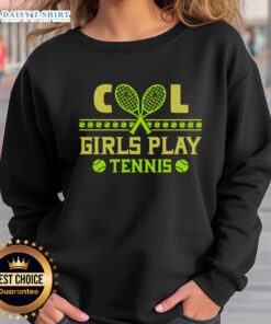 Nice cool girls in matching sweatshirts playing tennis on a sunny court, showcasing teamwork and fun.