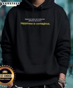 Smiling person wearing 'Happiness Is Contagious' hoodie, radiating joy and positivity in a vibrant outdoor setting.
