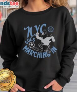 Alt Text: NYCFC fans wearing 'Nice New York City FC' sweatshirts marching in support of their team at a game.