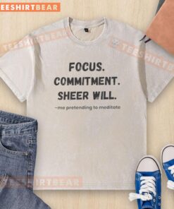 Official Focus Commitment Sheer Will Me Pretending to Meditate washed t-shirt displayed on a hanger with a serene backdrop.