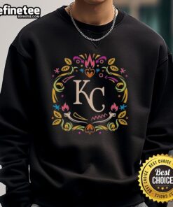 Official Kansas City Royals Dia de los Muertos MLB celebration sweatshirt featuring vibrant designs and team logo.