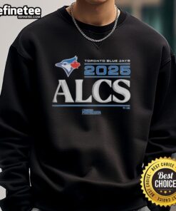 Alt Text: Official Toronto Blue Jays 2025 Division Series Winner sweatshirt displayed in locker room setting.