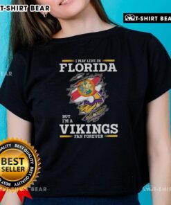 Original I May Live In Florida But I'm A Minnesota Vikings Fan Forever ladies tee in vibrant purple and gold design.