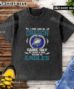 Alt Text: Washed t-shirt featuring 'I May Live In Oregon But My Heart Belongs To Philadelphia Eagles' design for fans.
