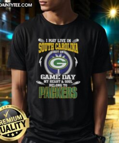 Green Bay Packers T-shirt with 'I May Live In South Carolina But On Game Day My Heart And Soul Belongs To' slogan.
