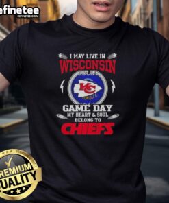 Premium I May Live In Wisconsin But On Game Day My Heart And Soul Belongs To Kansas City Chiefs T-Shirt displayed on a hanger.