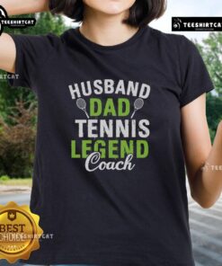 Pretty husband and dad coaching tennis, wearing a stylish ladies tee, showcasing his passion for the sport and family.