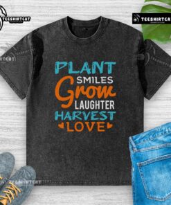 Colorful 'Pretty Plant Smiles Grow Laughter Harvest Love' washed t-shirt displayed on a wooden table, perfect for plant lovers.