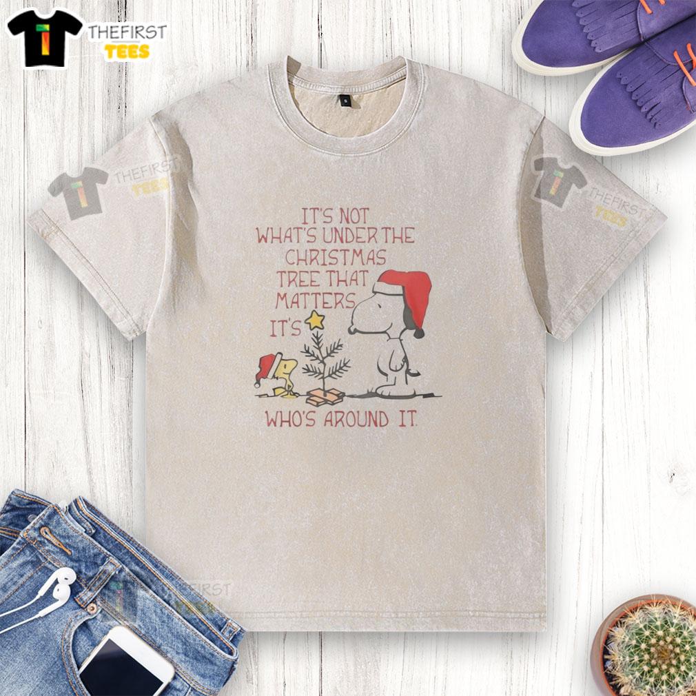 pretty-snoopy-woodstock-its-not-whats-under-the-christmas-tree-that-matter-its-whos-around-it-washed-t-shirt Pretty Snoopy and Woodstock on a washed t-shirt with the quote about Christmas, emphasizing family and togetherness.