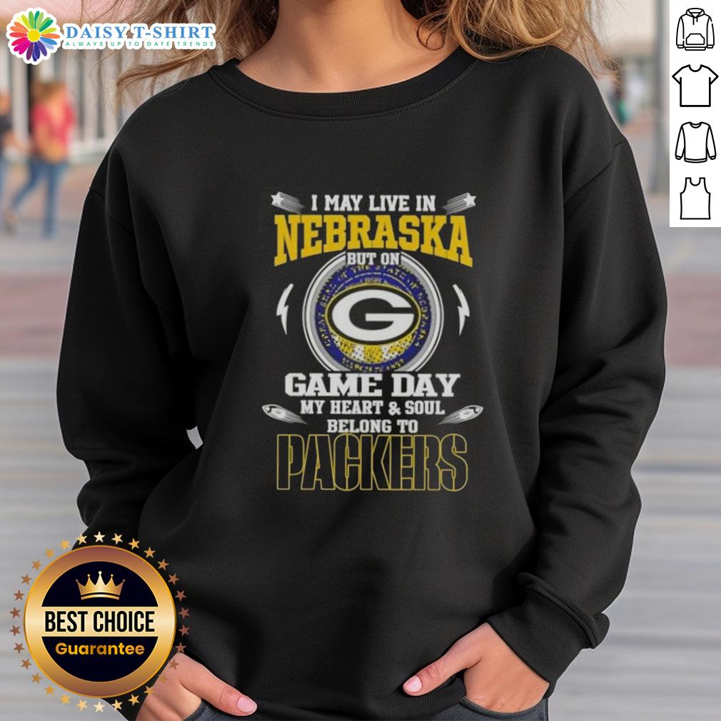 Top I May Live In Nebraska But On Game Day My Heart And Soul Belongs To Green Bay Packers Sweatshirt Alt Text: Green Bay Packers sweatshirt with 'I may live in Nebraska, but my heart belongs to Packers' slogan on display.