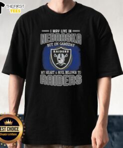 Alt Text: Top I May Live In Nebraska But On Gameday My Heart And Soul Belongs To Raiders T-Shirt design featuring team colors.