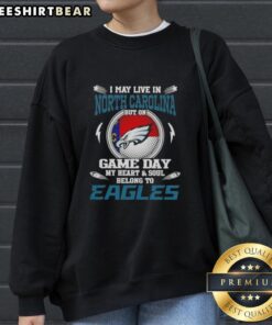 Cozy sweatshirt featuring 'I May Live In North Carolina But On Game Day My Heart Belongs To Philadelphia Eagles' design.