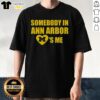 Alt Text: Top Michigan Somebody In Ann Arbor Loves Me T-Shirt featuring fun typography and vibrant colors, perfect for fans.
