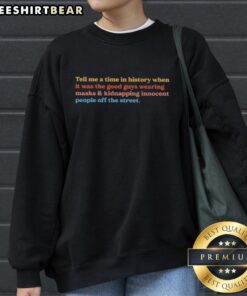 Top Tell Me A Time In History sweatshirt featuring a bold design of masked figures, capturing the irony of good guys kidnapping.
