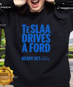 Top Tesla drives a Ford in a stylish 'Ready Set Ford' sweatshirt, showcasing unique automotive fashion.
