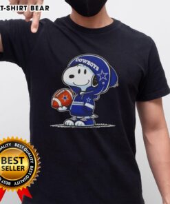 Alt Text: Peanuts Snoopy in a hoodie, smiling at fans while wearing a Dallas Cowboys T-shirt, showcasing team spirit.