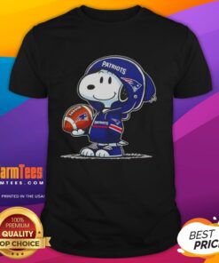 Alt Text: Awesome Peanuts Snoopy smiling in a hoodie with New England Patriots logo on a fun fan t-shirt design.