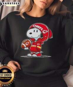 Snoopy in a Kansas City Chiefs hoodie smiling at fans, showcasing a cute Peanuts sweatshirt design.