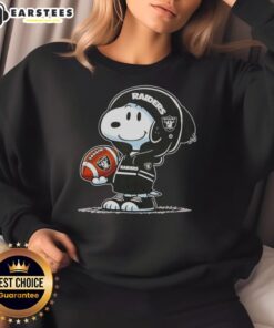 Alt Text: Cute Snoopy in a hoodie featuring Las Vegas Raiders, smiling at fans while wearing a cozy sweatshirt.