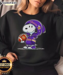 Alt Text: Cute Snoopy wearing a Minnesota Vikings hoodie, smiling at fans while showcasing a cozy sweatshirt design.