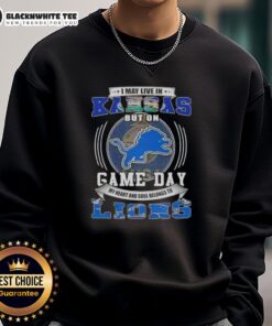 Alt Text: Cozy sweatshirt featuring Good I May Live In Kansas But On Game Day Detroit Lions Football design for fans.