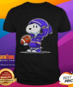 Alt Text: Snoopy in a hoodie smiling at fans on a Good Peanuts Baltimore Ravens T-shirt, showcasing team spirit and fun.