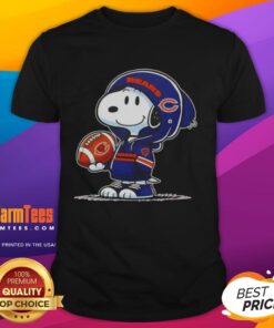 Alt Text: Snoopy wearing a Chicago Bears hoodie smiles at fans on a t-shirt featuring Good Peanuts design.