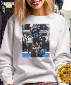 Alt Text: Official Detroit Lions Spiderman Amon-Ra St. Brown Superman sweatshirt featuring vibrant graphics and team colors.