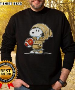 Alt Text: Snoopy in a hoodie supporting the New Orleans Saints, smiling at fans, featured on a stylish sweatshirt.