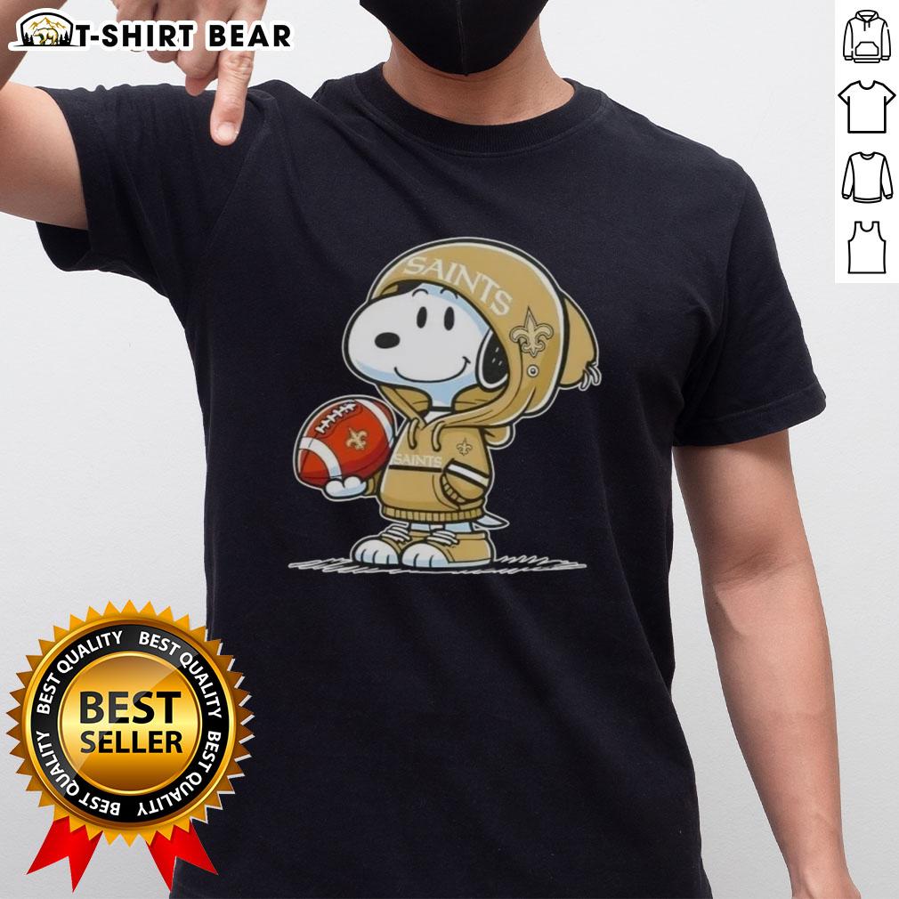 Official Peanuts Snoopy Wearing Hoodie New Orleans Saints And Smilling At Fans T-Shirt Alt Text: Snoopy in hoodie supporting New Orleans Saints, smiling at fans, featured on official Peanuts T-shirt design.