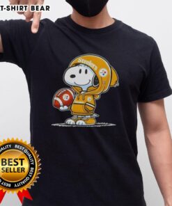 Alt Text: Peanuts Snoopy in a hoodie, smiling at fans, wearing a Pittsburgh Steelers T-shirt, perfect for NFL enthusiasts.