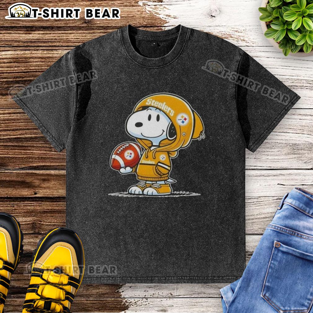 Official Peanuts Snoopy Wearing Hoodie Pittsburgh Steelers And Smilling At Fans Washed T-Shirt Alt Text: Snoopy in a hoodie smiles at fans, showcasing an Official Peanuts Pittsburgh Steelers washed t-shirt design.