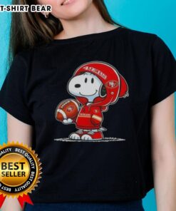 Snoopy in a hoodie, smiling at fans, wearing San Francisco 49ers gear on a ladies' tee. Official Peanuts merchandise.