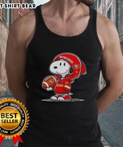 Snoopy in a hoodie smiles at fans in San Francisco 49ers tank top, showcasing official Peanuts merchandise.