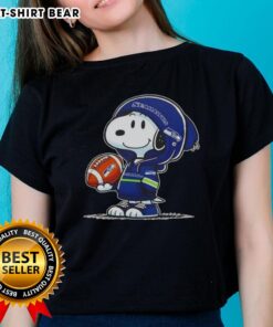 Alt Text: Snoopy in a hoodie smiling at fans, wearing Seattle Seahawks gear on a ladies' tee, perfect for Peanuts fans.