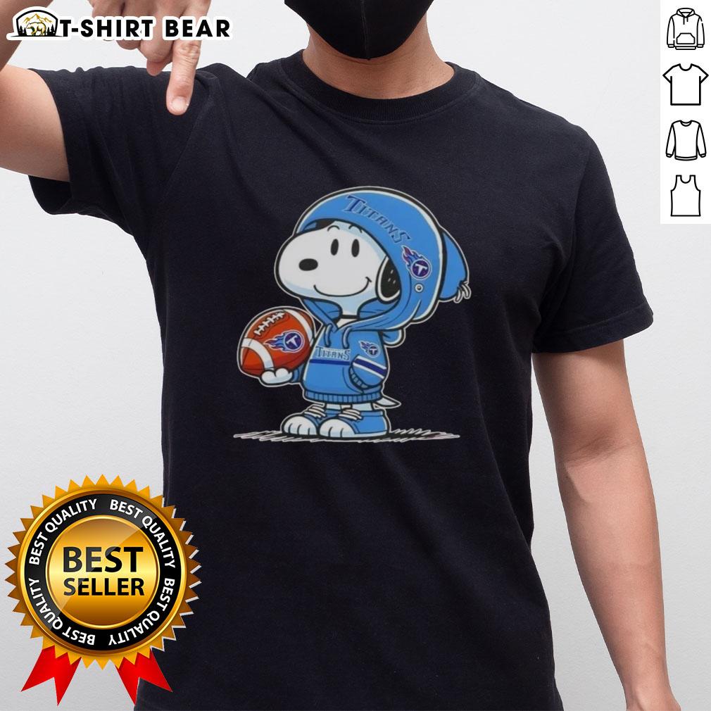 Official Peanuts Snoopy Wearing Hoodie Tennessee Titans And Smilling At Fans T-Shirt Snoopy wearing a Tennessee Titans hoodie smiles at fans on a fun graphic t-shirt featuring Peanuts characters.