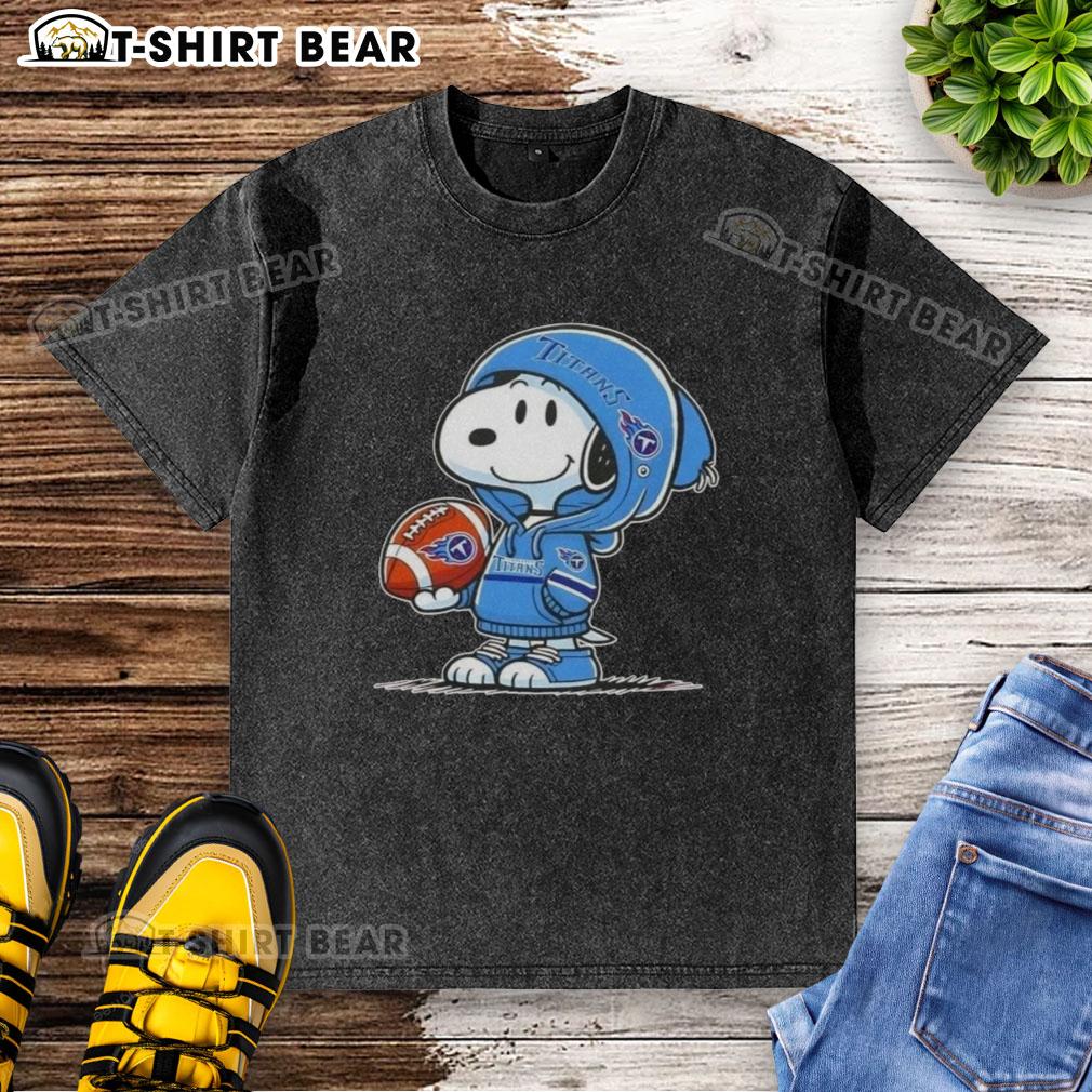 Official Peanuts Snoopy Wearing Hoodie Tennessee Titans And Smilling At Fans Washed T-Shirt Snoopy wearing a Tennessee Titans hoodie smiles at fans on a washed t-shirt, showcasing official Peanuts merchandise.