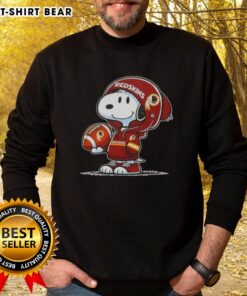 Alt Text: Snoopy in a Washington Commanders hoodie smiles at fans, showcasing the official Peanuts sweatshirt design.