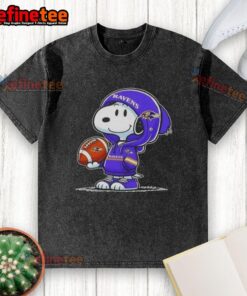 Premium Peanuts Snoopy wearing a Baltimore Ravens hoodie, smiling at fans on a washed t-shirt design.