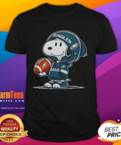 Alt Text: Snoopy in a hoodie smiling at fans, featuring a Philadelphia Eagles design on a fun t-shirt for Peanuts lovers.