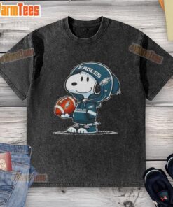 Alt Text: Snoopy in a hoodie, smiling at fans, features a Philadelphia Eagles design on a washed t-shirt. Perfect for Peanuts fans!