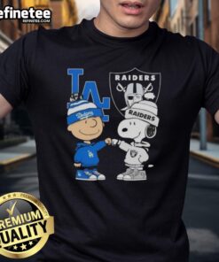 Awesome Charlie Brown fist bump with Snoopy on a Los Angeles Dodgers X Raiders T-shirt, perfect for sports fans.