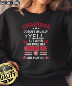 Awesome grandma in Alabama Crimson Tide sweatshirt, excitedly cheering during a game, showcasing her team spirit.