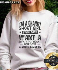 Cranky short girl wearing a sarcastic sweatshirt that says 'If you don't want a sarcastic answer, don't ask a stupid question.'